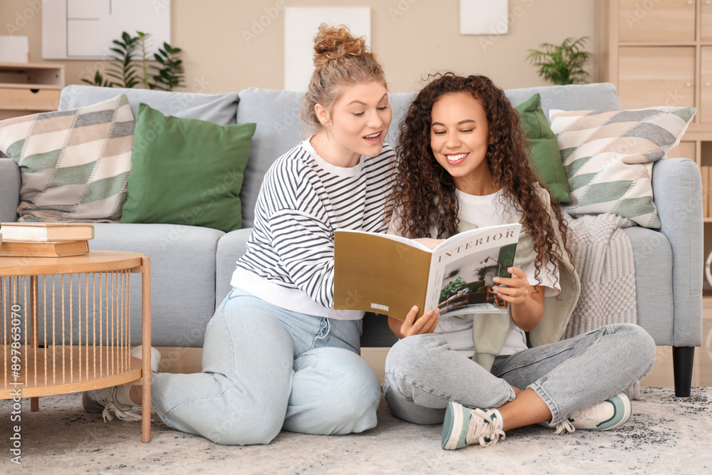 Young women reading magazine in living room Young women reading magazine in living room