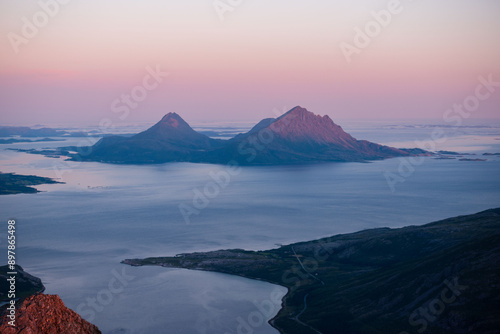 Midnight sun sunset view over Tomma island, in the archipelagio of Northern Norway, Helgeland. Smaltind, Breitind and Tortenviktind in the foreground.