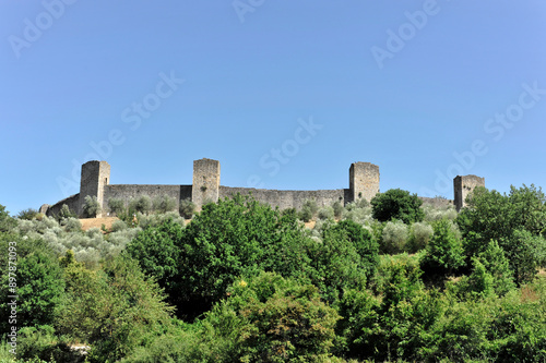 Stadtmauer mit Wehrtürmen, Monteriggioni, Toskana, Italien, Europa, Mittelalterliche Burg auf einem Hügel mit Mauern und Türmen, umgeben von Bäumen, klarer Himmel, Toscana, Europa