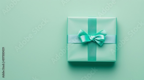 Elegant turquoise gift box with a ribbon bow on a pastel background