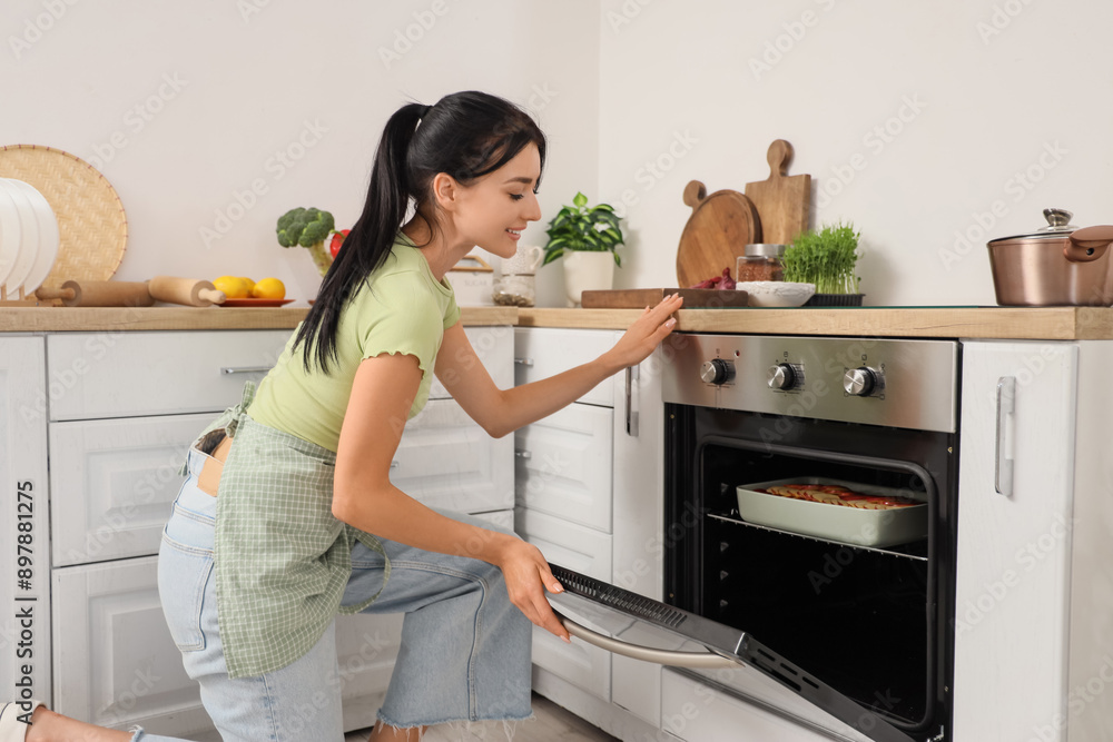 Young woman baking apple pie in oven at home Young woman baking apple pie in oven at home