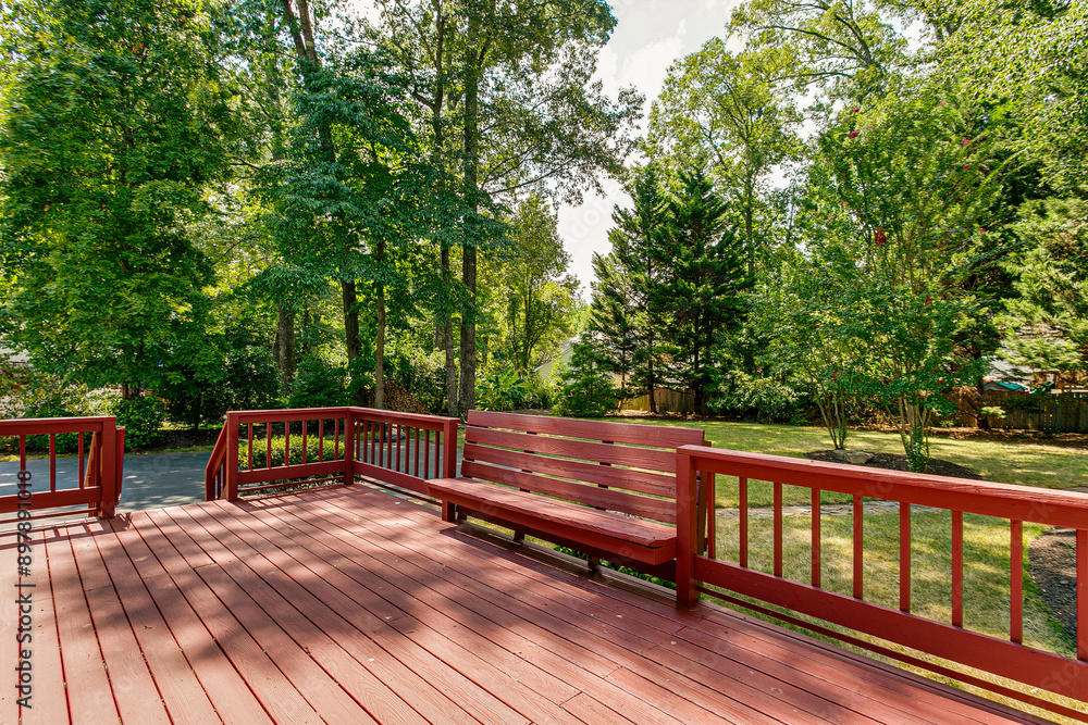 Red Deck In A Backyard Surrounded By Lush Green Trees And Bushes with Built in Bench Red Deck In A Backyard Surrounded By Lush Green Trees And Bushes with Built in Bench