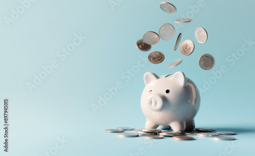 White piggy bank with coins falling against a blue background.