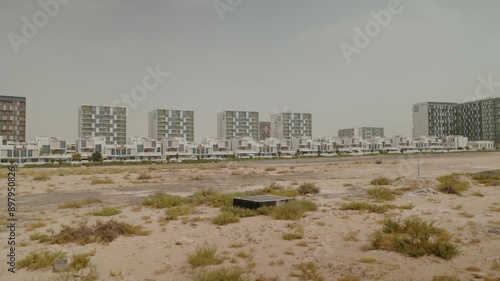 Explore Dubai South’s residential district with a playground, grand market, park, and lush greenery. Featuring trees and ongoing community construction near Al Maktoum Airport. photo