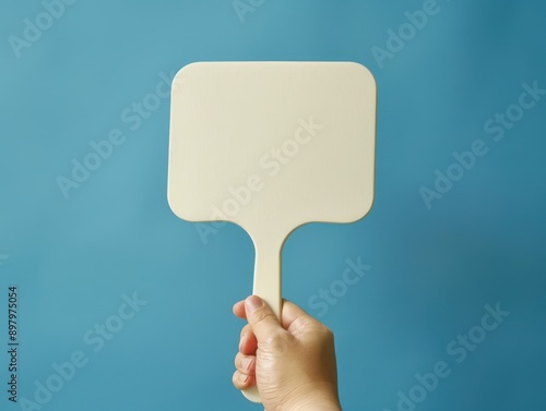 Hand holding a blank auction paddle, bidding and commerce concept