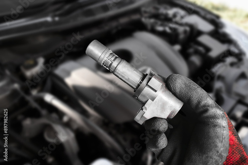 Obraz na płótnie A mechanic hand holds an ignition coil for a spark plug of a car engine , Automotive parts concept w salonie