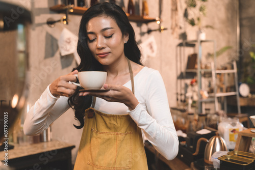 portrait of waitress handing and sip a coffee and present coffee with smiling. the happiness woman in coffee shop on waitress uniform and service customer.