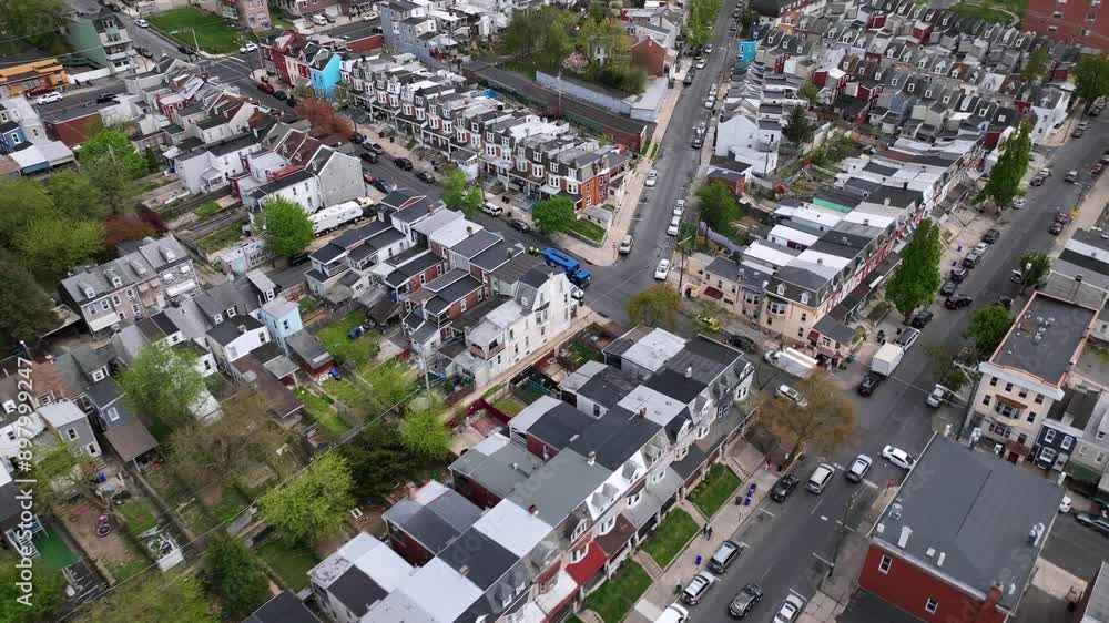 Row of houses in american style during sunny day in small town of USA. Roofing flight with traffic on main street at daytime in spring. Aerial top down flyover. Row of houses in american style during sunny day in small town of USA. Roofing flight with traffic on main street at daytime in spring. Aerial top down flyover.