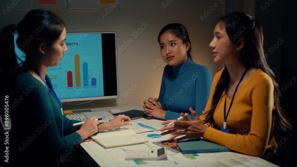 Three businesswomen discussing market trends in a modern office setting with charts. Engaging in professional conversation and collaboration on financial analysis Three businesswomen discussing market trends in a modern office setting with charts. Engaging in professional conversation and collaboration on financial analysis