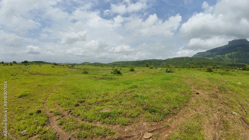 Fototapeta premium Peaceful plains surrounded by lush greenery and hills