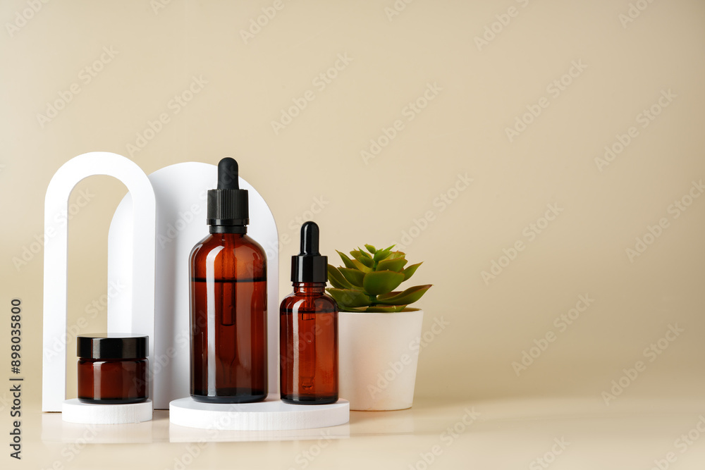 Set of brown glass bottles with essential oils on stand on beige background Set of brown glass bottles with essential oils on stand on beige background