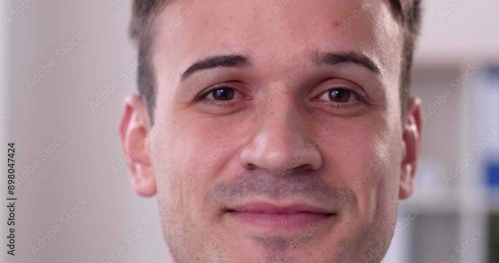 Closeup shot of a happy adult man. Close up video portrait of a face of a young male model looking at the camera, smiling and blinking his eyes several times Closeup shot of a happy adult man. Close up video portrait of a face of a young male model looking at the camera, smiling and blinking his eyes several times