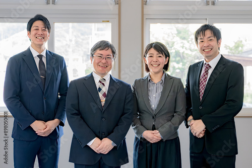爽やかな笑顔の４人のスーツ男女