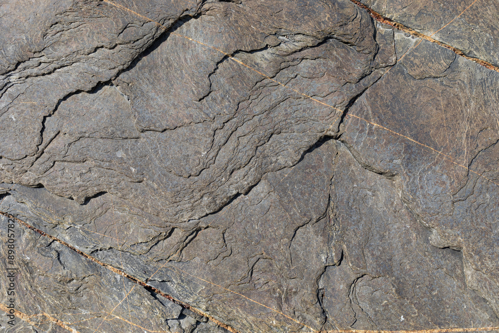 Naklejka premium Sea-worn stone texture on a wild coastal beach.