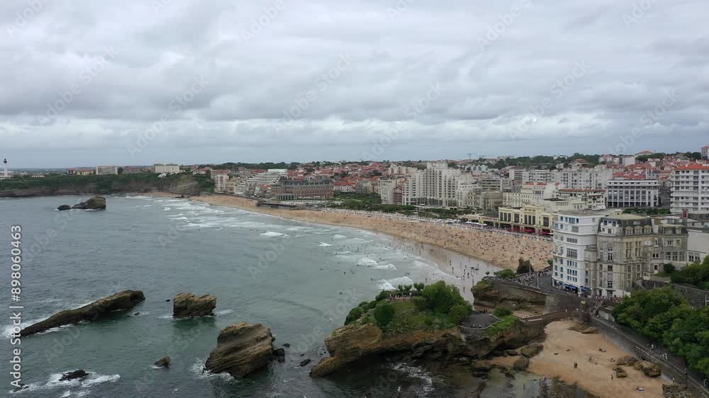 Aerial view of a drone flying over the rocky coastline and beach of Biarritz, France, on a cloudy summer day Aerial view of a drone flying over the rocky coastline and beach of Biarritz, France, on a cloudy summer day