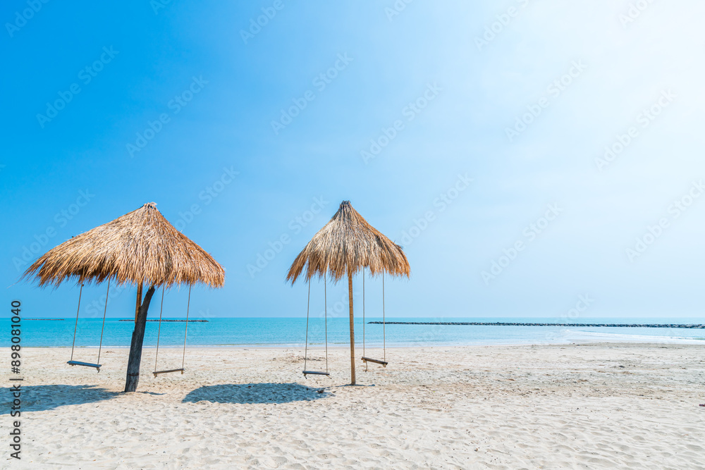 Beautiful swings under Nipa palm umbrella and beach with white sand of the sea on the beach blue sky with clouds on a hot sunny day background ,travel summer holiday Thailand Beautiful swings under Nipa palm umbrella and beach with white sand of the sea on the beach blue sky with clouds on a hot sunny day background ,travel summer holiday Thailand