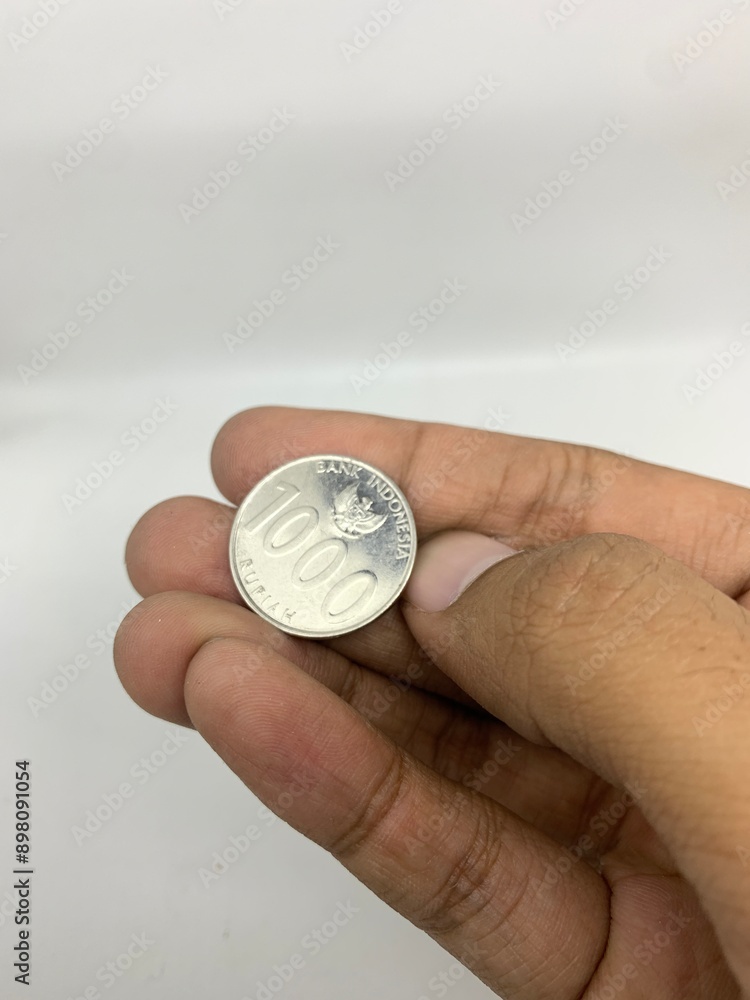 Hand holding coins in Indonesian rupiah Hand holding coins in Indonesian rupiah