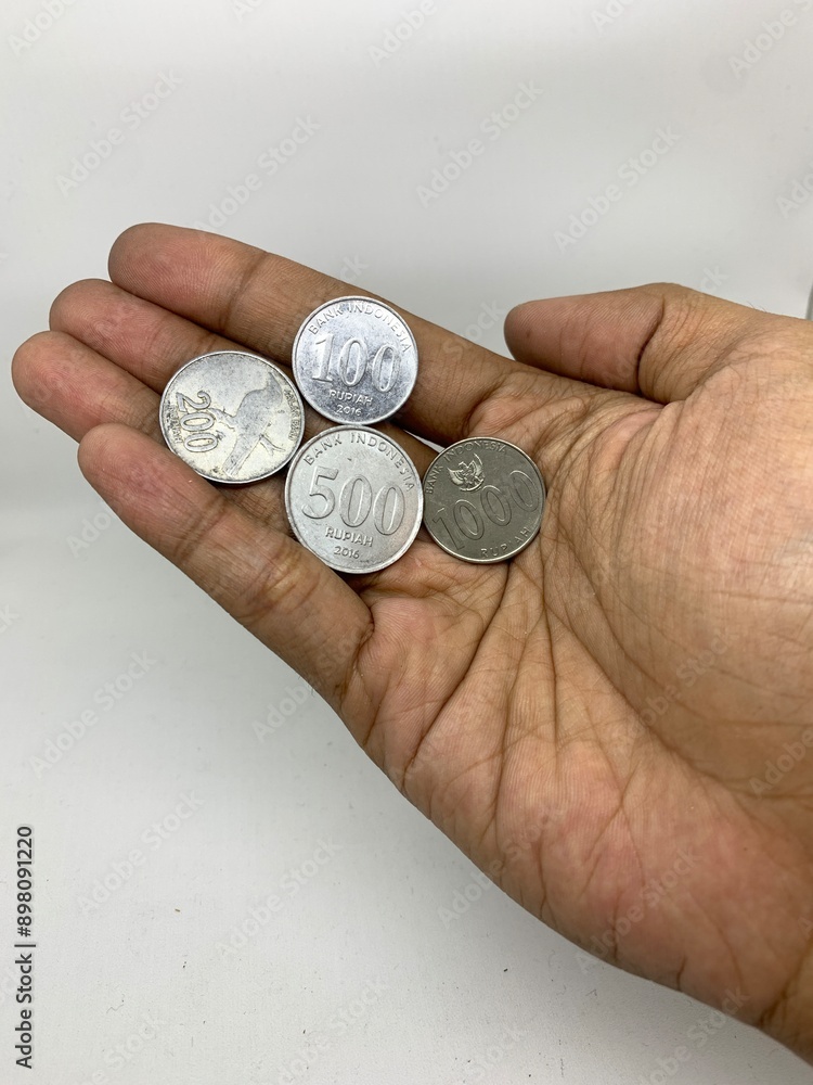 Hand holding a many coins in Indonesian rupiah Hand holding a many coins in Indonesian rupiah