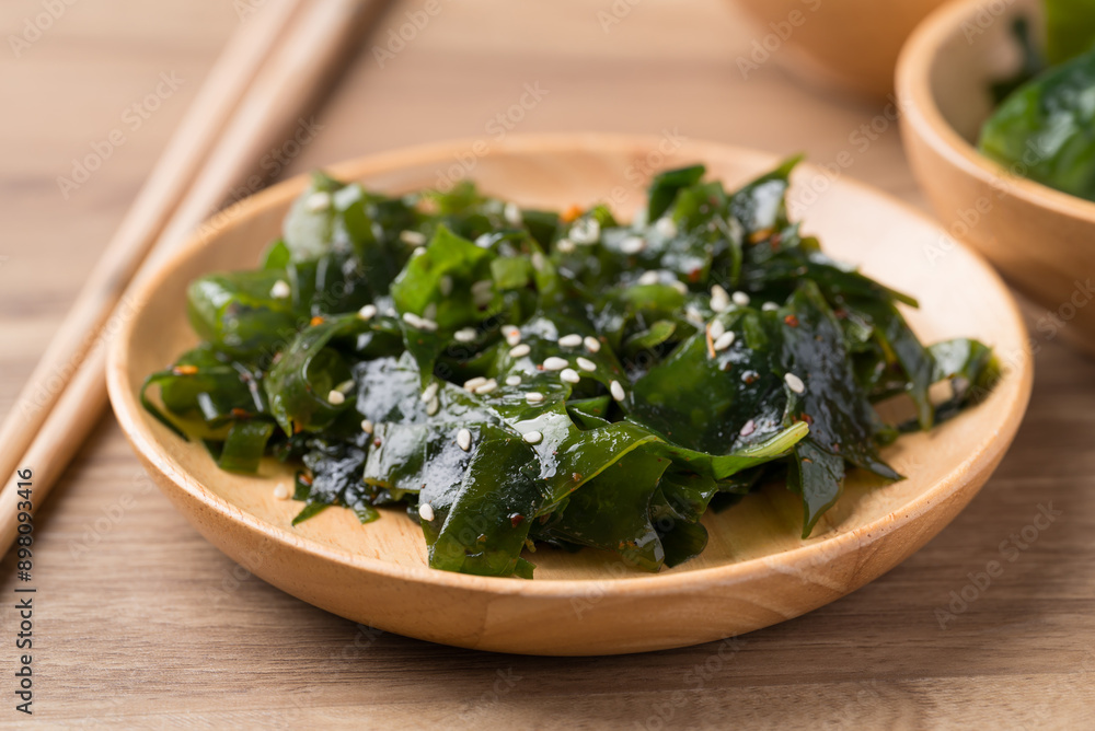 Wakame seaweed or sea mustard salad on wooden bowl, Healthy eating Wakame seaweed or sea mustard salad on wooden bowl, Healthy eating
