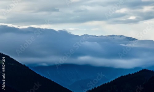 timelapse of clouds rolling over a mountain range.