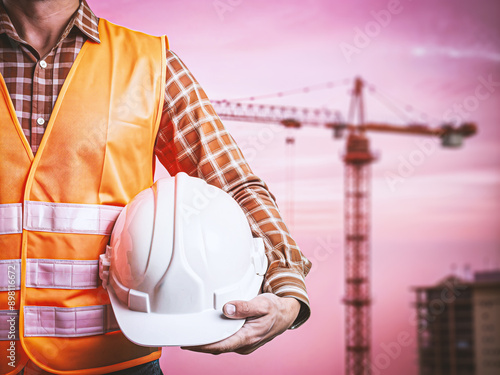 Architect worker holding yellow helmet a for workers security control at city site.