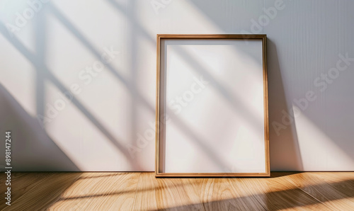 Wooden photo frame on the floor near a wall with sunlight and sh photo