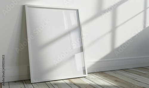 Minimalist white frame against textured wall with dappled sunlig photo