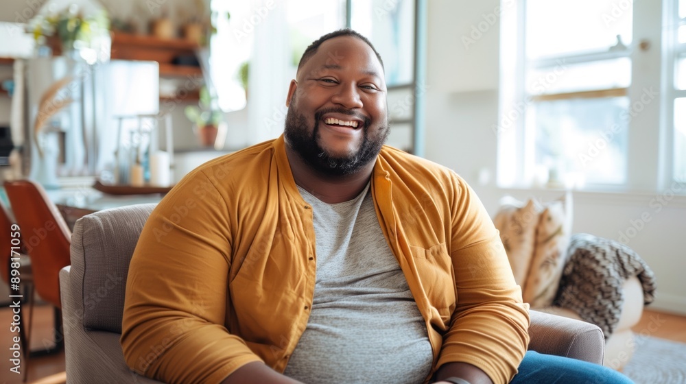 Cheerful overweight man smiling widely, enjoying a moment at home, portraying happiness and contentment - body positivity, happiness, and relaxed moments. Cheerful overweight man smiling widely, enjoying a moment at home, portraying happiness and contentment - body positivity, happiness, and relaxed moments.