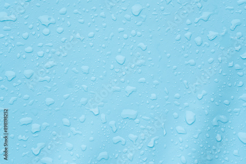 Water droplets on blue surface create textured background, giving a serene and refreshing vibe