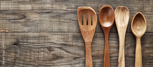 Cooking utensils displayed on a table with a wooden spoon and fork in a flat lay allowing for a text overlay on the copy space image