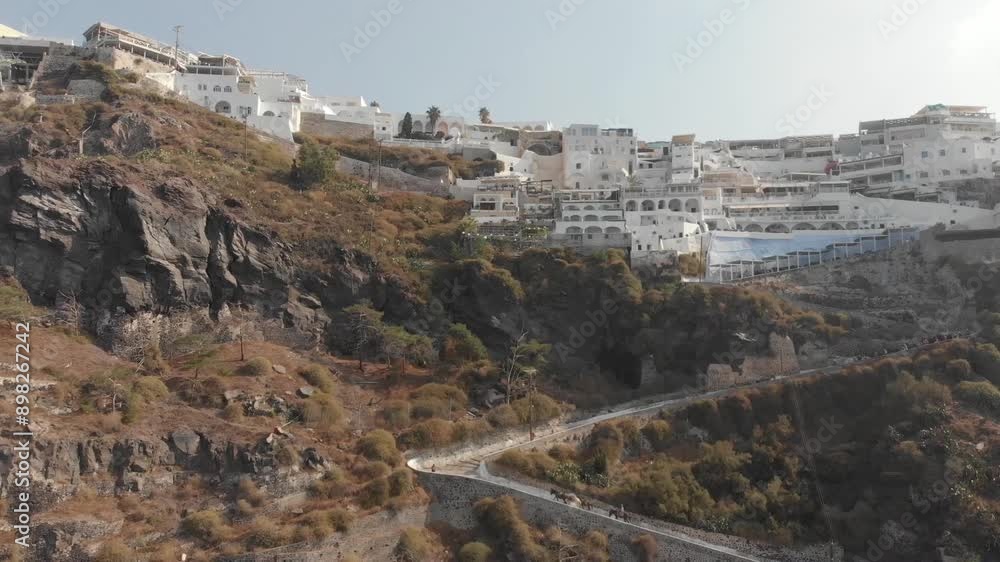 Aerial panorama drone view from above of path road from the port to the top which can be walked or ridden by horse or donkey. Fira, Santorini Island, Greece. Thira city. Aegean Sea, Mediterranean.
Aerial panorama drone view from above of path road from the port to the top which can be walked or ridden by horse or donkey. Fira, Santorini Island, Greece. Thira city. Aegean Sea, Mediterranean.