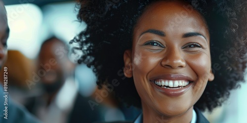 A young woman with an afro hairstyle smiling directly into the camera