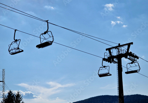 The chair lift in the mountains transports skiers to the slopes in the winter and cyclists riding trill tracks on mountain bikes in the summer.