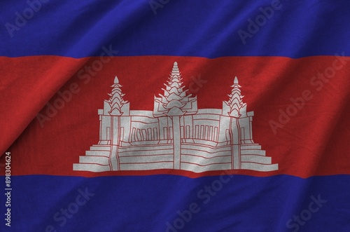 Cambodia flag depicted on folded wavy fabric of old cloth close up photo