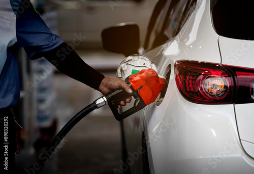 The gas station employee is filling diesel fuel for customers. photo