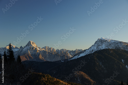 Obraz na płótnie cime e catene montuose innevate lontane di un ambiente naturale di montagna nell'italia nord orientale, al tramonto, in inverno, con un cielo sereno w salonie