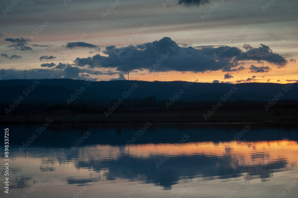 Fototapeta premium Summer sunset over wheat field. Beautiful sunset sky over countryside