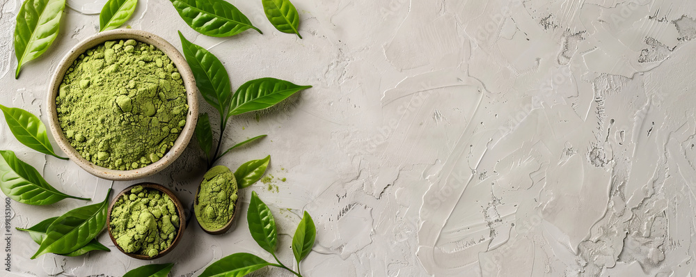 Obraz premium Mockup of matcha tea powder with leaves on a light gray background, offering a neutral and modern backdrop with room for text or graphics.
