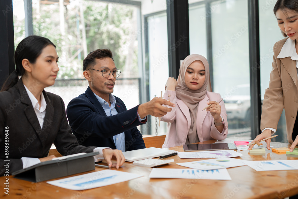 Group of Asian business men and women sitting and looking at documents at the office. Group of Asian business men and women sitting and looking at documents at the office.