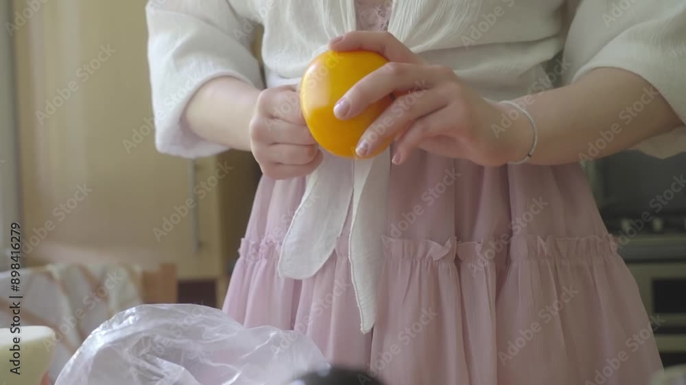 Girl prepares yellow tomatoes for eating. Organic food from the local market processed at home. Health benefit of fresh food Girl prepares yellow tomatoes for eating. Organic food from the local market processed at home. Health benefit of fresh food