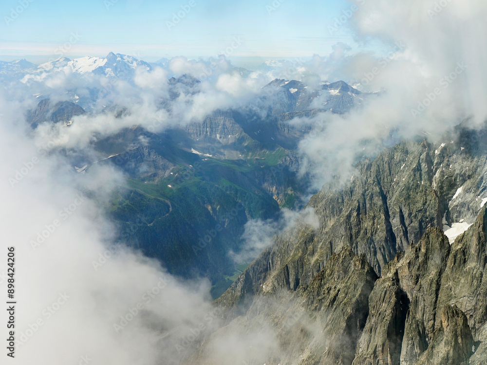Fototapeta premium Looking Down at the French Alps Through the Clouds from a Gondola