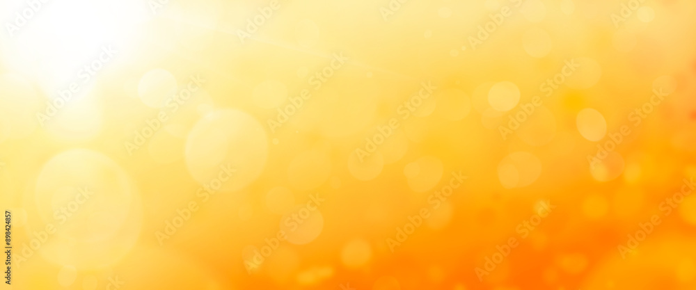 A hot summer sky background with warm golden orange and yellow blurred field, foliage..
