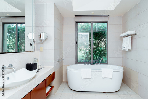 Modern White Bathroom Design with Freestanding Bathtub. Light shine through from a side.
