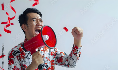 Asian person wearing red white flag ribborn and megaphone for indonesia independence photo