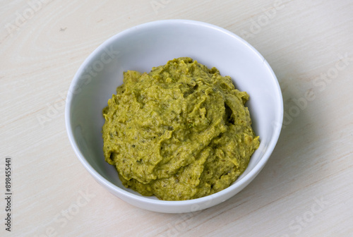 Potol vorta in a white ceramic bowl on wooden surface. Bhorta is the simplest and traditional food from Bangladesh and the Bengal region of India. photo