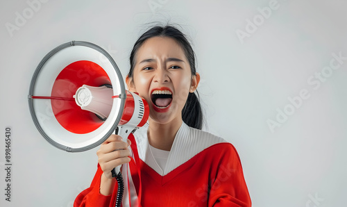 Asian person wearing red white flag ribborn and megaphone for indonesia independence photo