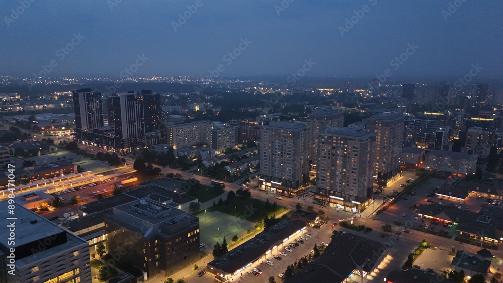 Fototapeta premium Aerial footage of the urban cityscape of Waterloo illuminated at sunset in Ontario, Canada