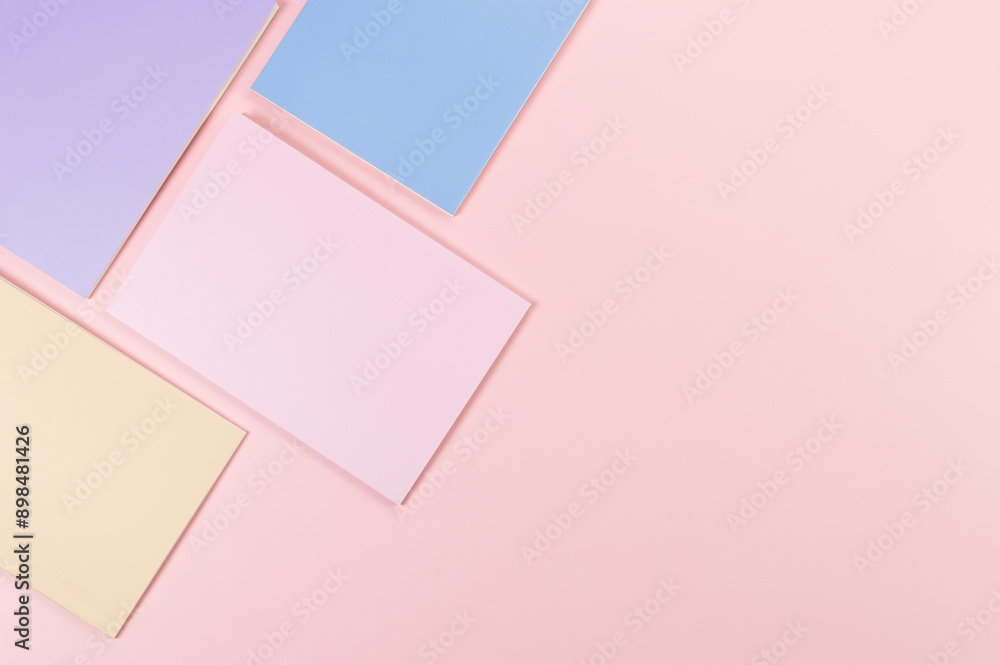 Top view of pink, purple, blue and beige notebooks on pink background. School, office wallpaper. Flat lay, copy space. Top view of pink, purple, blue and beige notebooks on pink background. School, office wallpaper. Flat lay, copy space.