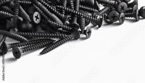 The black screws. Black screws are piled on a white background