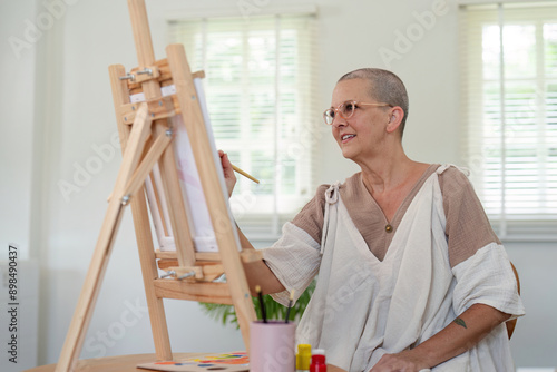 Senior woman painting on canvas at home, Elderly woman painting on a canvas, Happy retirement concepts